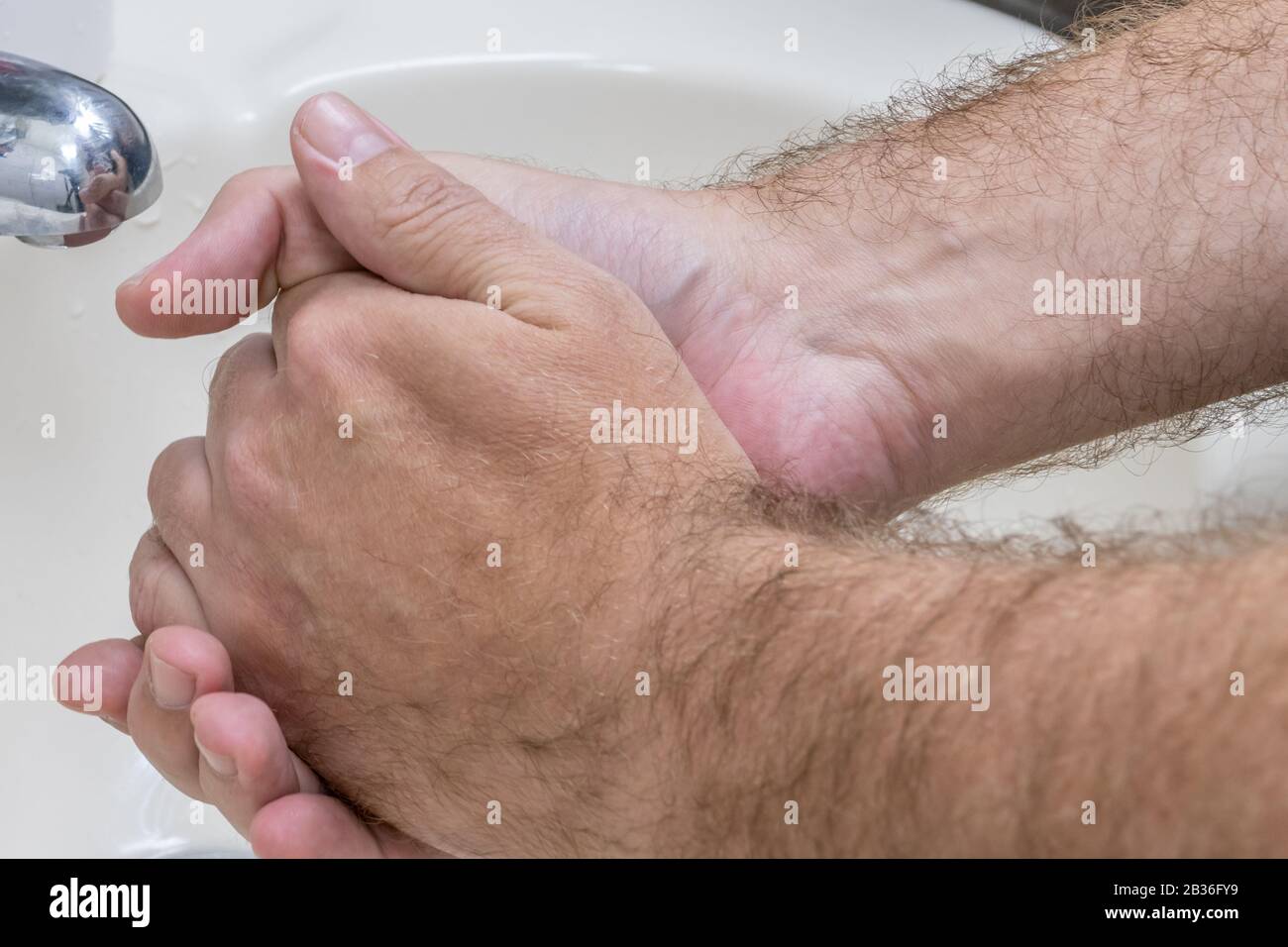 Homme se laver les mains dans le bassin de gros plan, un de plusieurs dans la série de marches de lavage des mains Banque D'Images