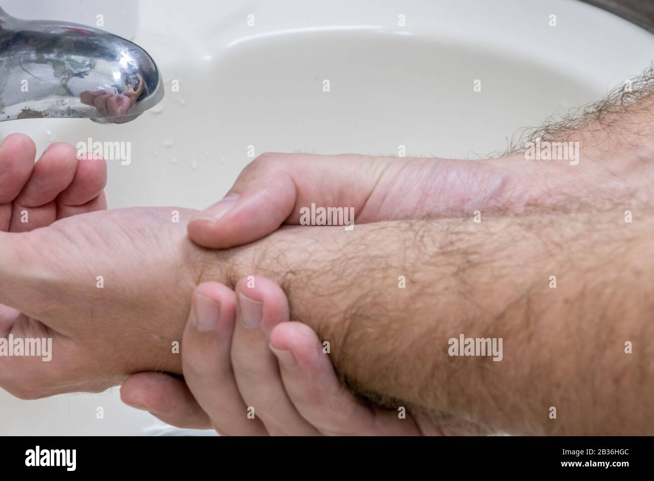 Homme se laver les mains dans le bassin de gros plan, un de plusieurs dans la série de marches de lavage des mains Banque D'Images