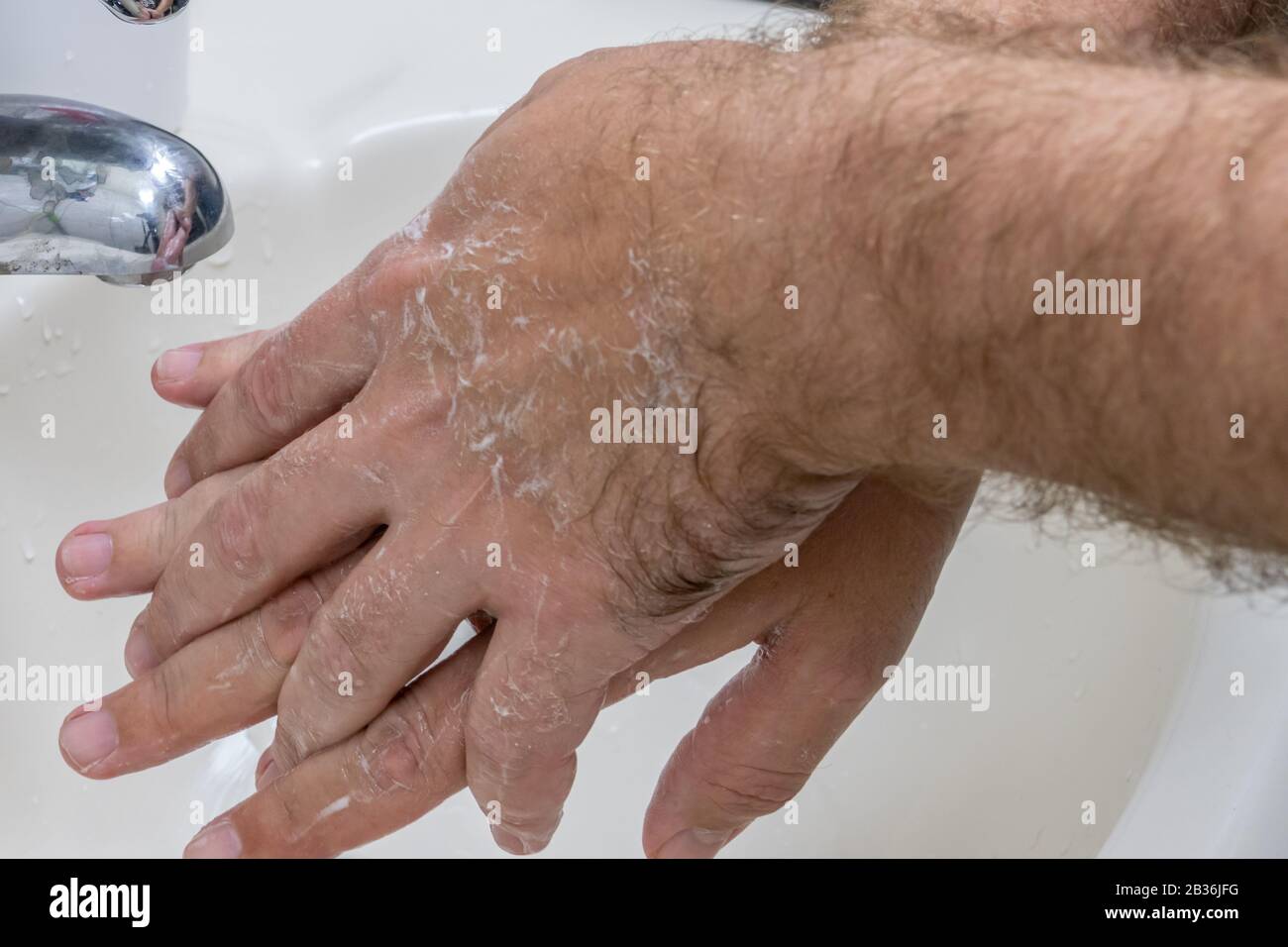 Homme se laver les mains dans le bassin de gros plan, un de plusieurs dans la série de marches de lavage des mains Banque D'Images