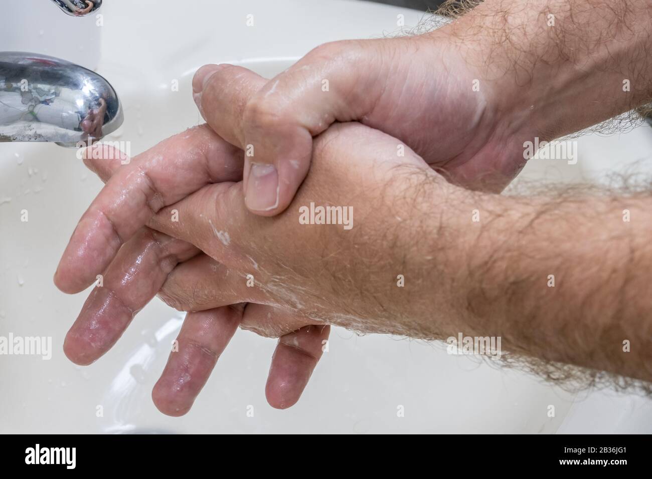 Homme se laver les mains dans le bassin de gros plan, un de plusieurs dans la série de marches de lavage des mains Banque D'Images
