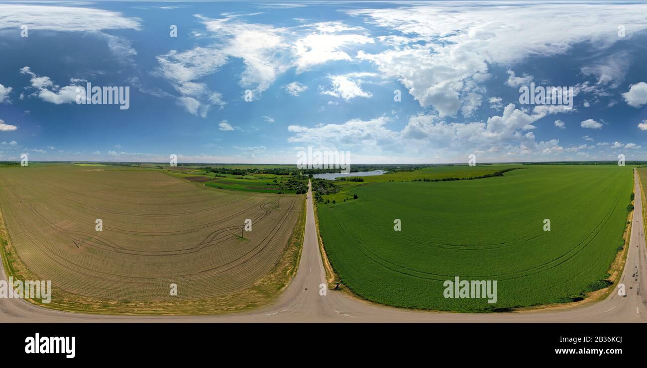 Paysage de champ vert et marron. Terres agricoles et route. Magnifique ciel bleu avec de grands nuages Banque D'Images