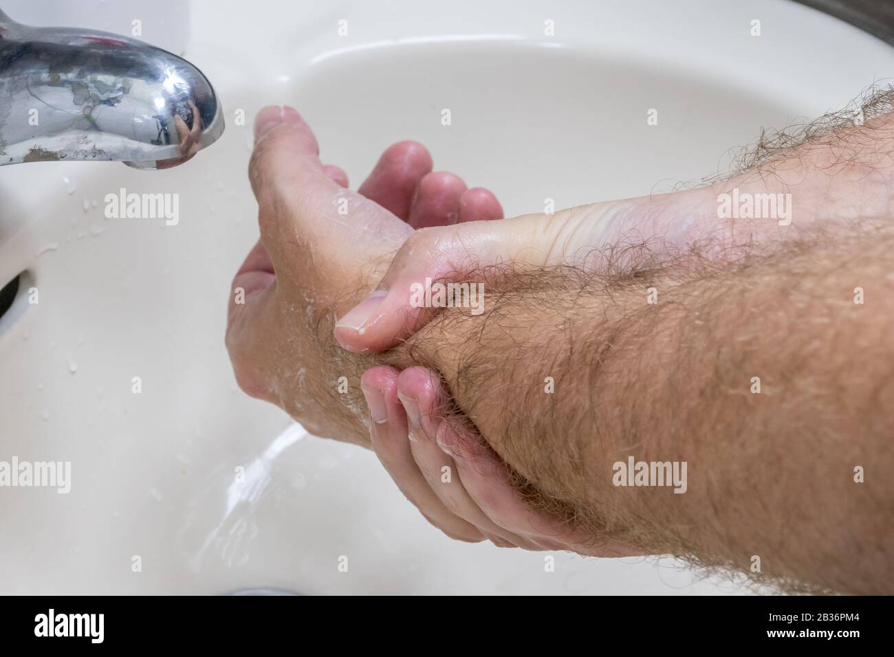 Homme se laver les mains dans le bassin de gros plan, un de plusieurs dans la série de marches de lavage des mains Banque D'Images