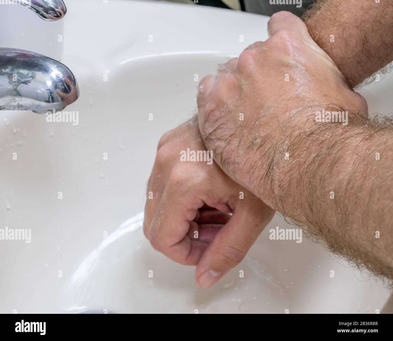 Homme se laver les mains dans le bassin de gros plan, un de plusieurs dans la série de marches de lavage des mains Banque D'Images