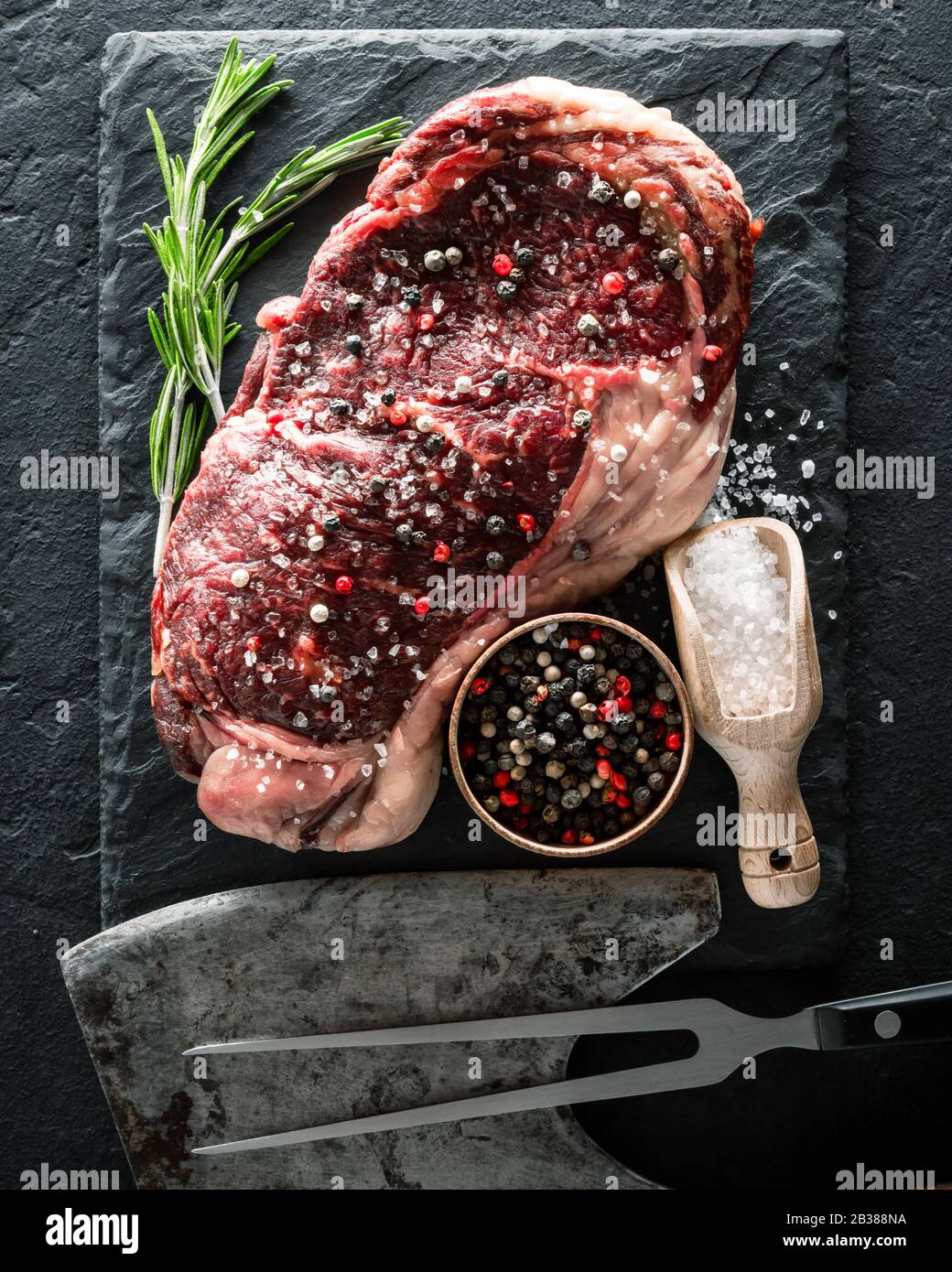 Le persillage Ribeye Steak sur plaque noire. Hacher la viande de boeuf Banque D'Images