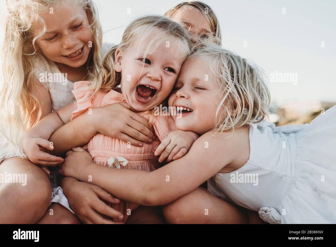 Gros plan sur le rire d'un enfant entouré de jeunes sœurs Banque D'Images