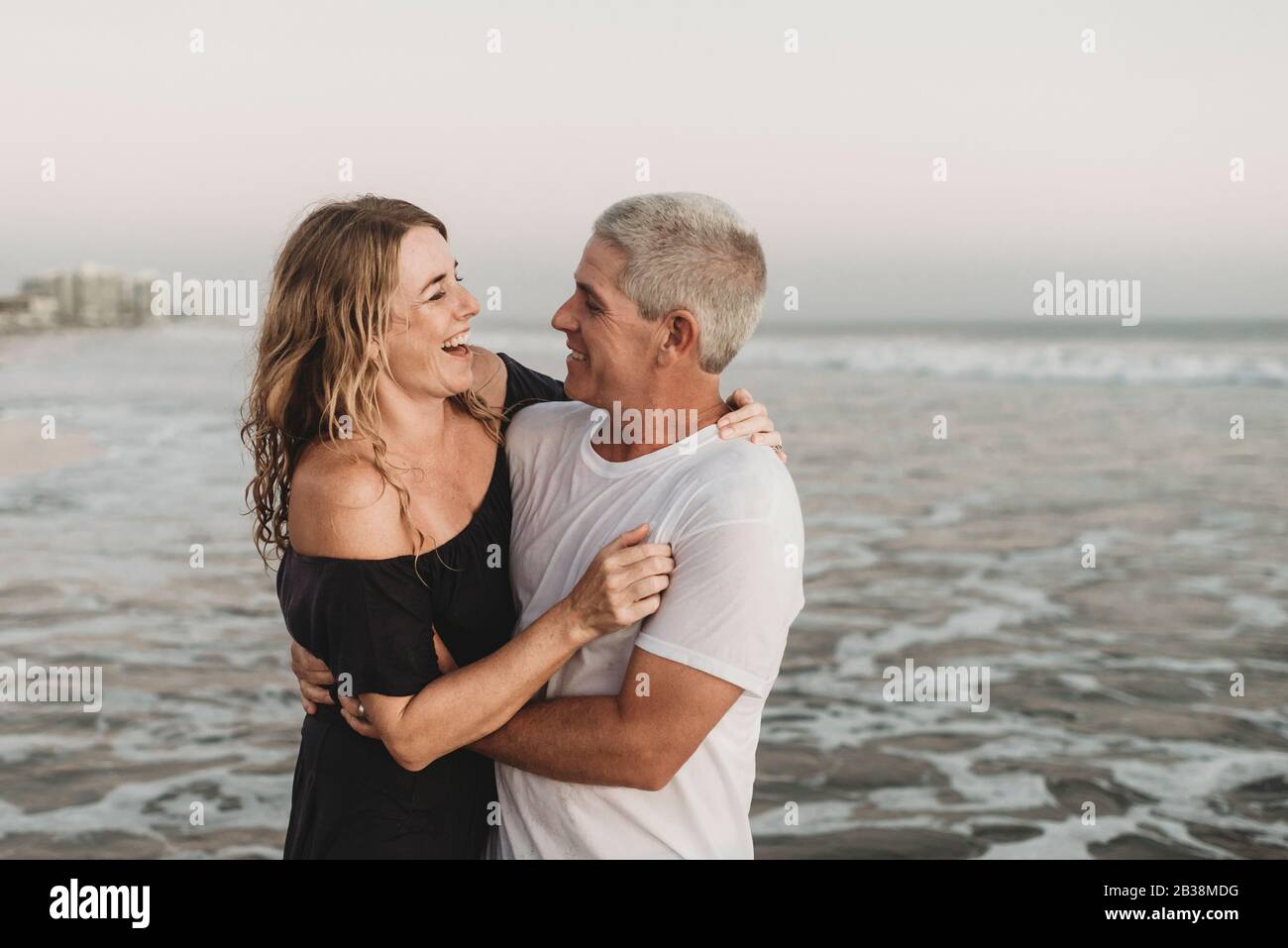 Vue latérale d'un couple marié regardant l'un l'autre dans l'océan Banque D'Images