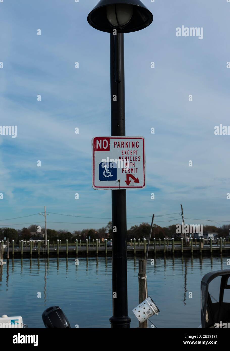 Un poteau de lampe à une marina a un panneau qui lit, pas de parking sauf vihicules avec un permis pour le stationnement handicapés. Banque D'Images