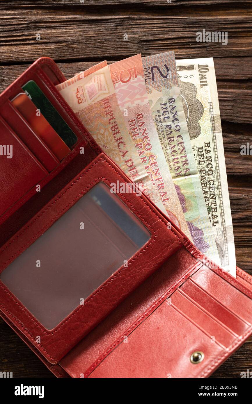 Argent paraguayen dans le portefeuille sur le plan de table en bois Banque D'Images