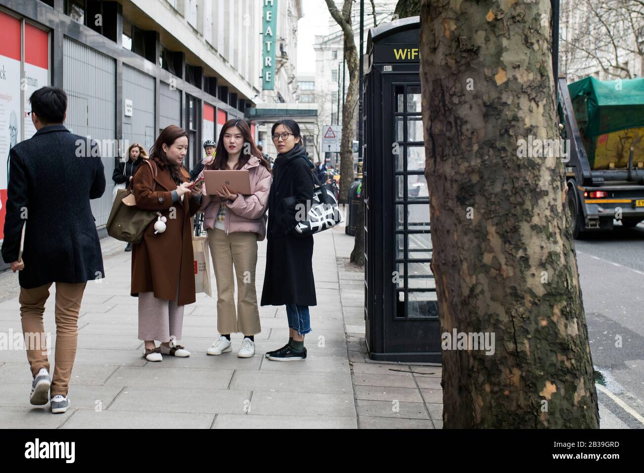 Londres, Royaume-Uni - 13 février 2020, Trois filles asiatiques avec un ordinateur portable Macintosh cherchent un ordinateur pour trouver un itinéraire. Banque D'Images