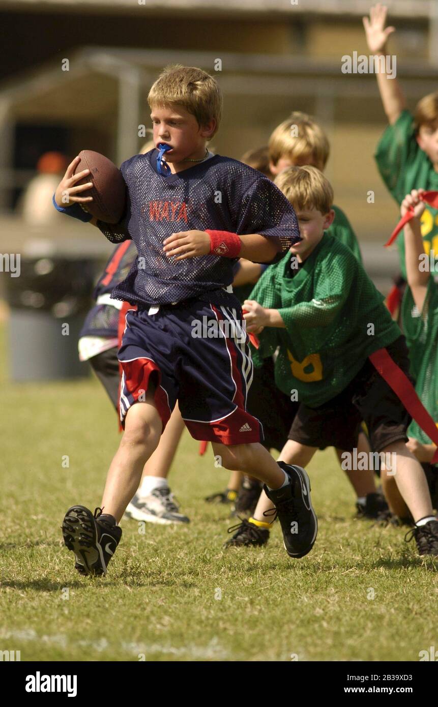Austin, Texas, États-Unis, octobre 2004 : les garçons portant des protecteurs de bouche en plastique courent en terrain bas lors d'un match de football drapeau de la ligue de la jeunesse pour les 7-8-ans.©Bob Daemmrich Banque D'Images