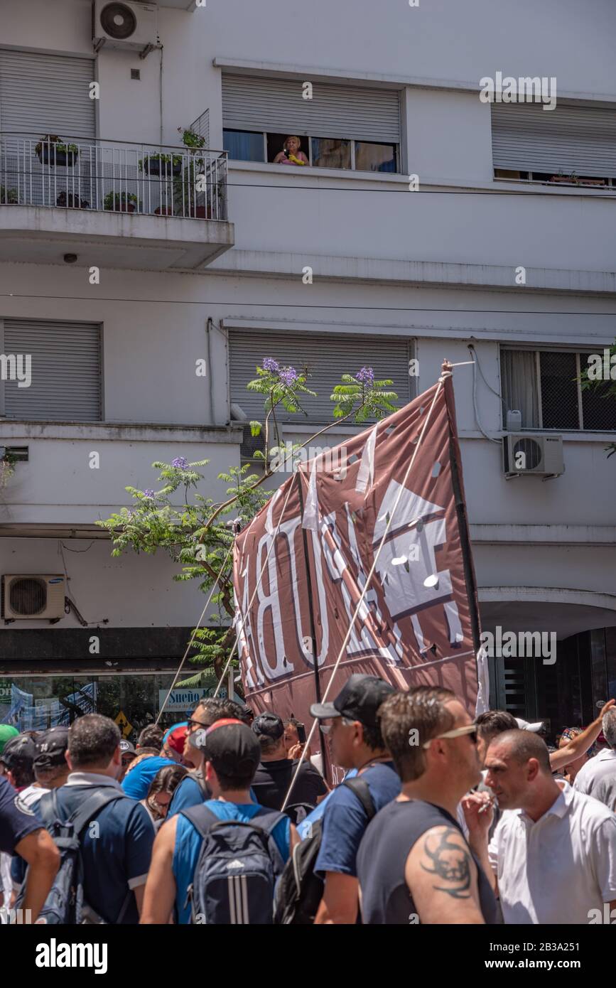 Buenos Aires, Argentine; 10 décembre 2019: Une femme nettoyage des maisons avec ses gants de travail sur la recherche de la fenêtre pour la mobilisation dans le soutien et la cel Banque D'Images