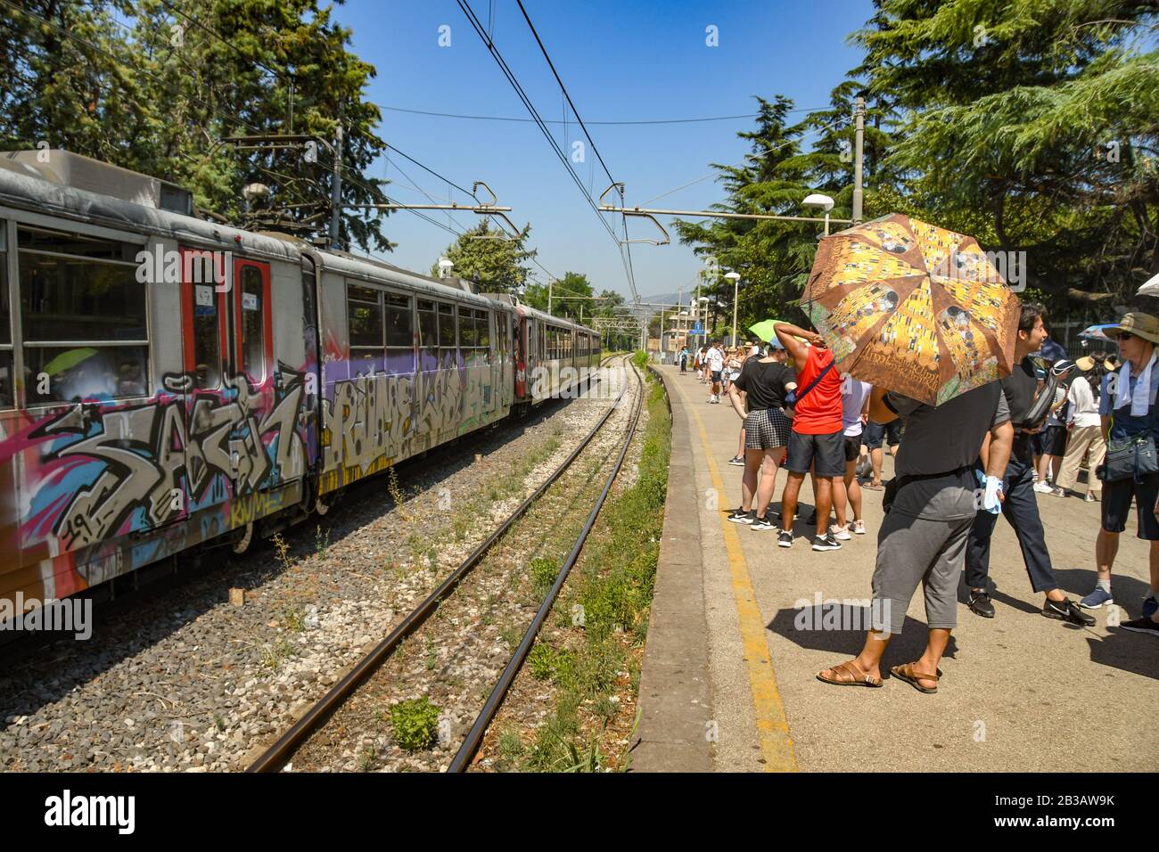 Pompéi, PRÈS DE NAPLES, ITALIE - AOÛT 2019: Les gens sur la plate-forme 1 de la gare de Pompéi Scavi attendant de prendre un train pour Sorrente. Un train s'est arrêté Banque D'Images