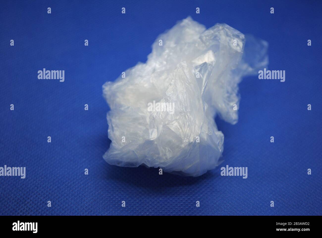Sac en plastique transparent blanc écrasé en polyéthylène transparent sur fond bleu Banque D'Images