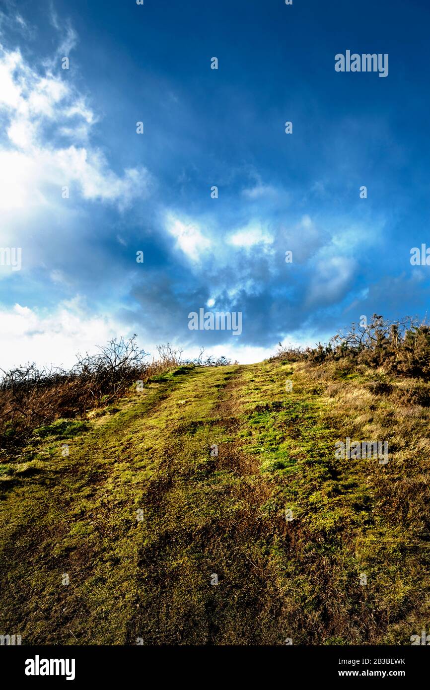 Chemin en montée vers le ciel bleu et les nuages blancs devant, dans le club de golf d'Aberdeen avec nuages et champ d'herbe. Nigg Bay, Écosse. Banque D'Images