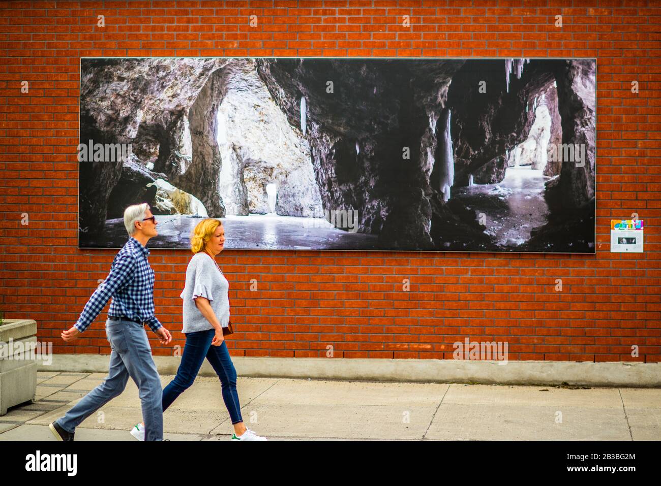 Saint-Lambert, Canada - 26 mai 2019: Un couple marchant passe une grande image sur la rue Saint-Lambert Banque D'Images