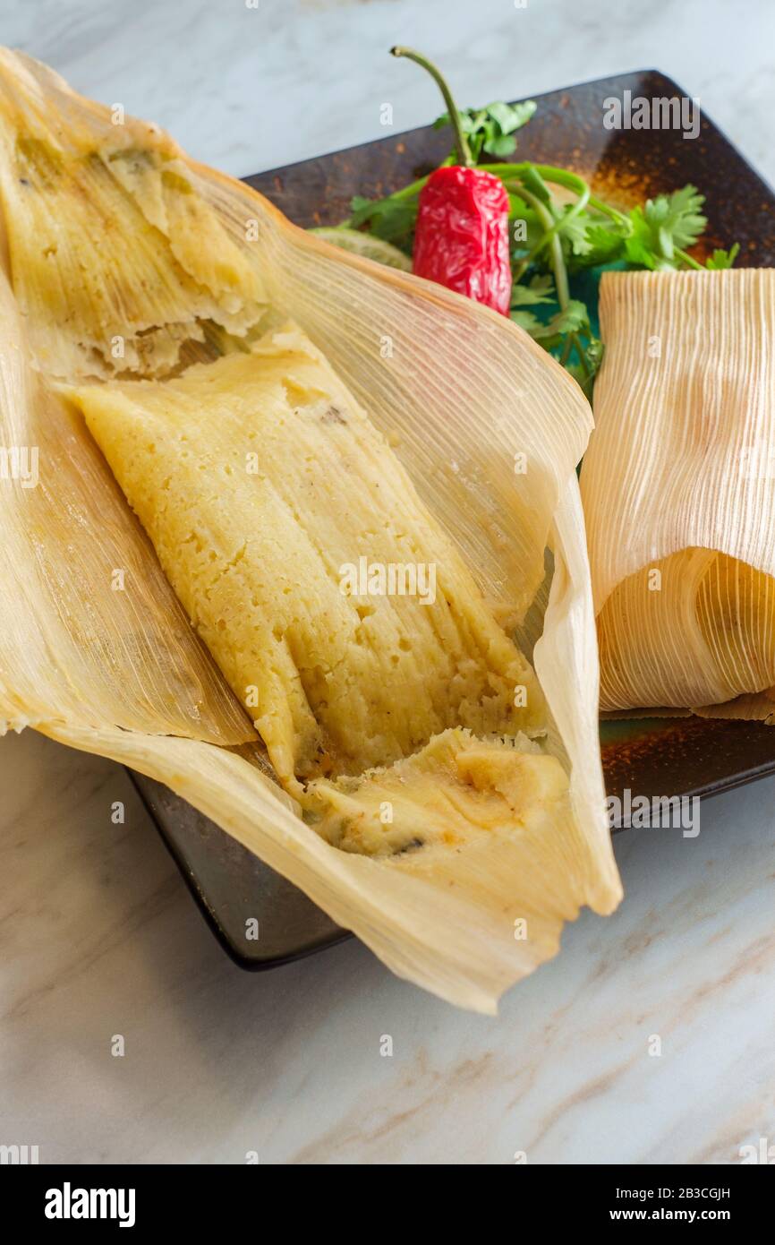 Masa tamales mexicain au Chili et au fromage cuits à la vapeur enveloppés dans une coque de maïs Banque D'Images