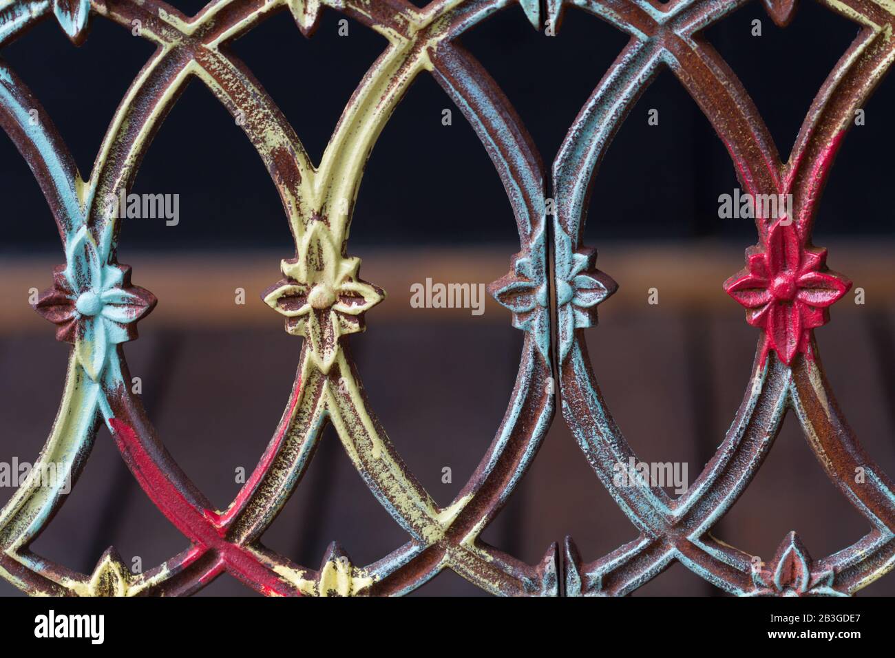 Ancienne clôture en fer multicolore avec symboles fleuris. Banque D'Images