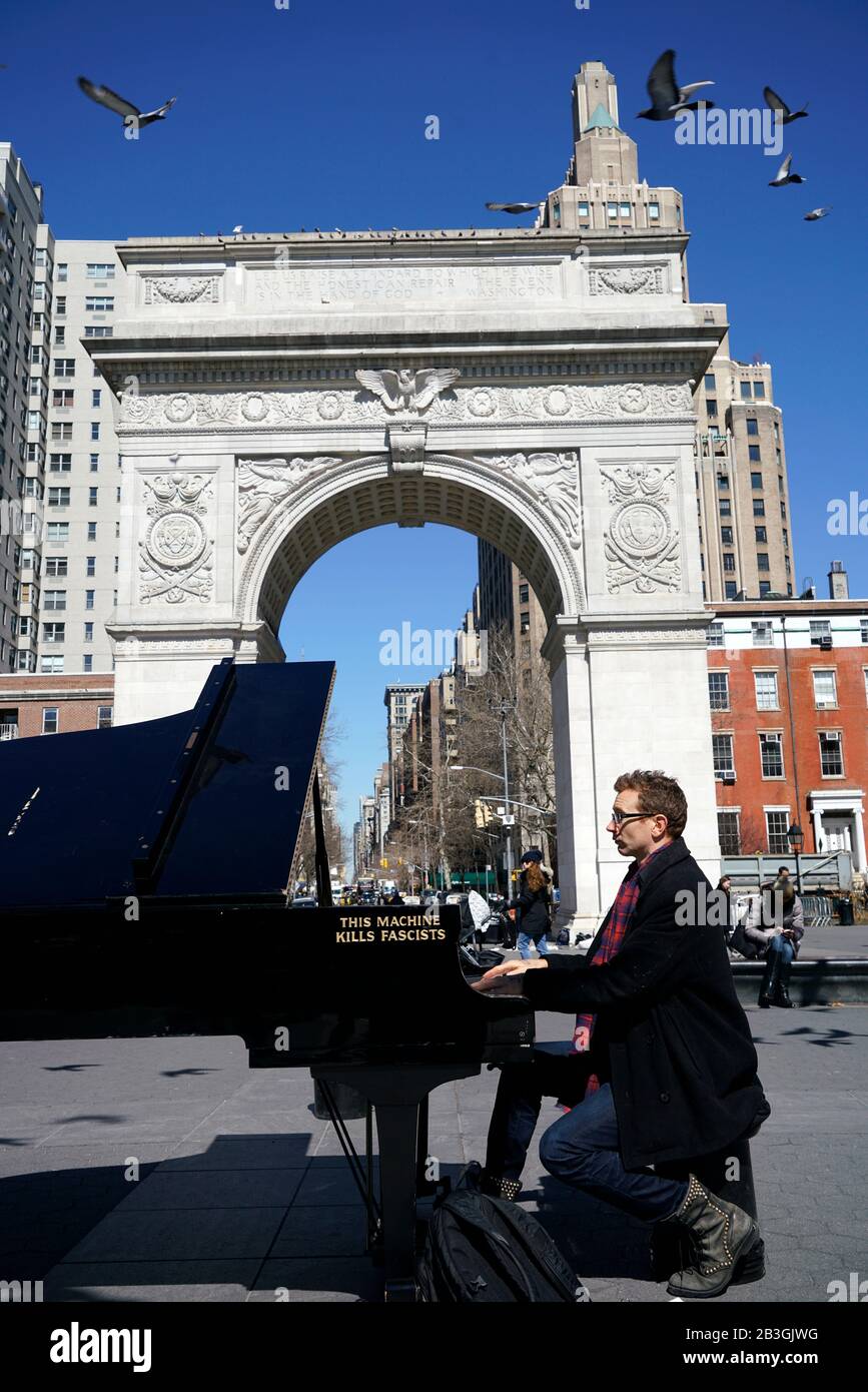 Pianiste jouant un piano à queue avec Wood Guthrie's. Dire cette machine Kills Fascists écrit sur lui .Washington Square Park.New York City.USA Banque D'Images