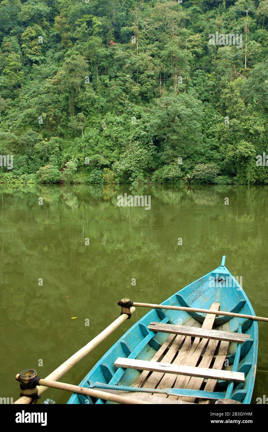 Vue sur un lac et un bateau en bois bleu à côté d'une forêt à Puncak, Java Ouest, Indonésie. Banque D'Images