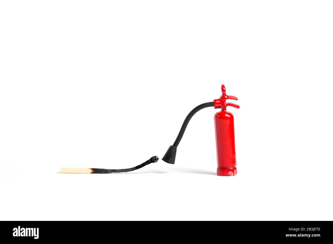 Micro-extincteur à proximité d'un match brûlé sur fond blanc, macro shot Banque D'Images