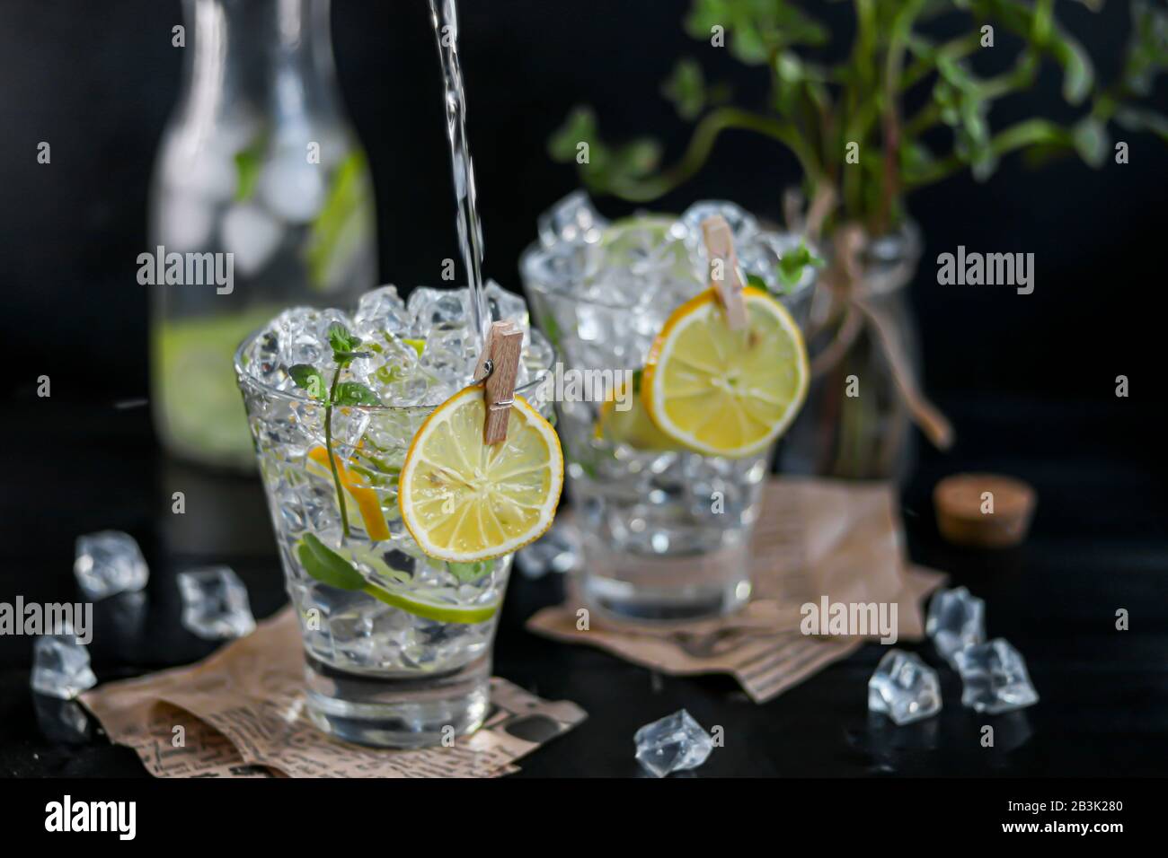 Rafraîchissement été cocktail alcoolique Marguerite avec glace pilée, citron vert et menthe pour la décoration. Éclaboussures de vodka. Sur un fond en bois sombre. Sur le congé Banque D'Images