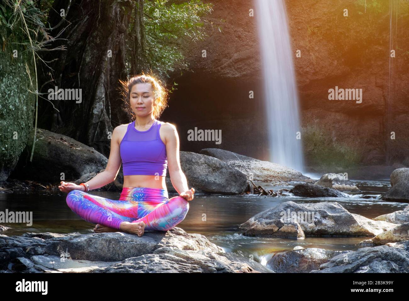 femme pratique le yoga devant la cascade Banque D'Images