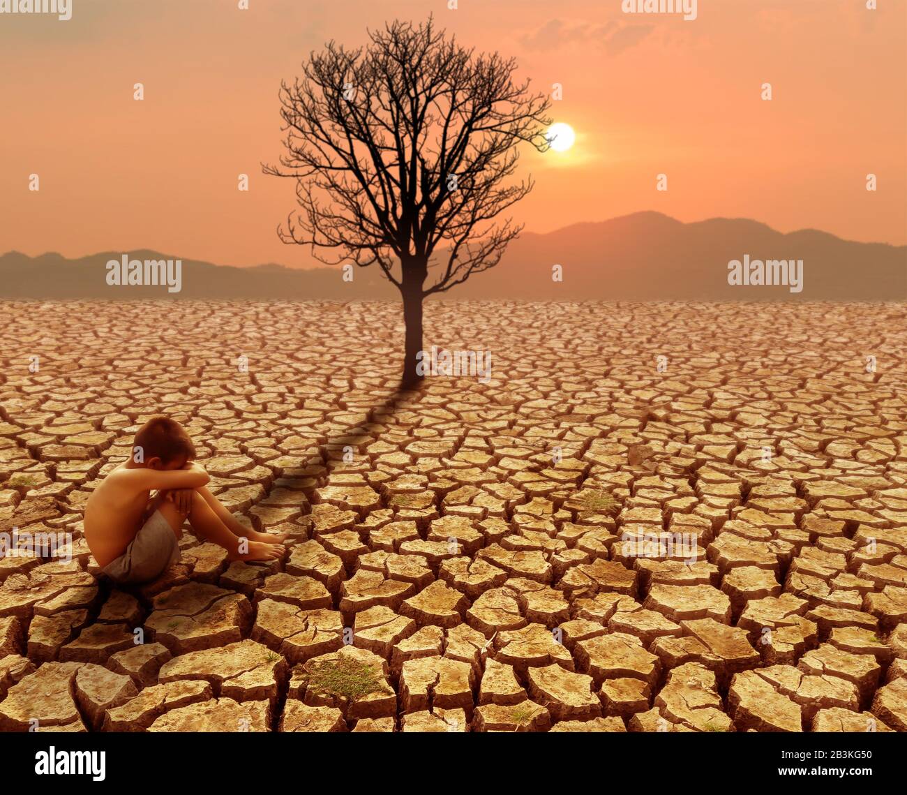 Les enfants assis sur terre crack dans la zone aride avec arbre mort et climat chaud, changement climatique et concept de réchauffement climatique Banque D'Images