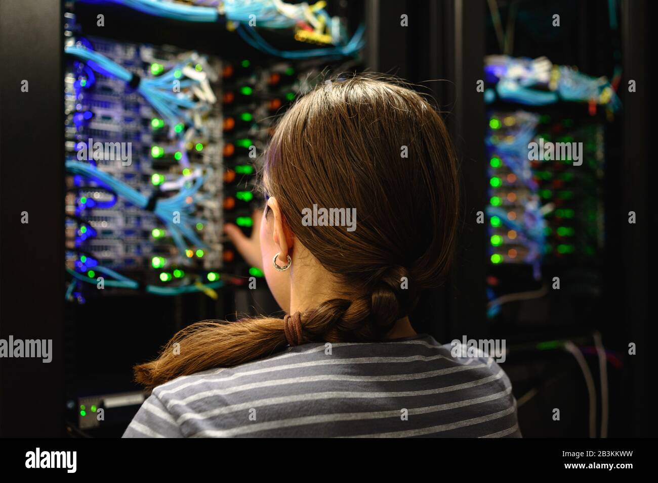 Femme ingénieur réseau près du rack de serveurs en service. Centre de données de la société INFORMATIQUE moderne Banque D'Images