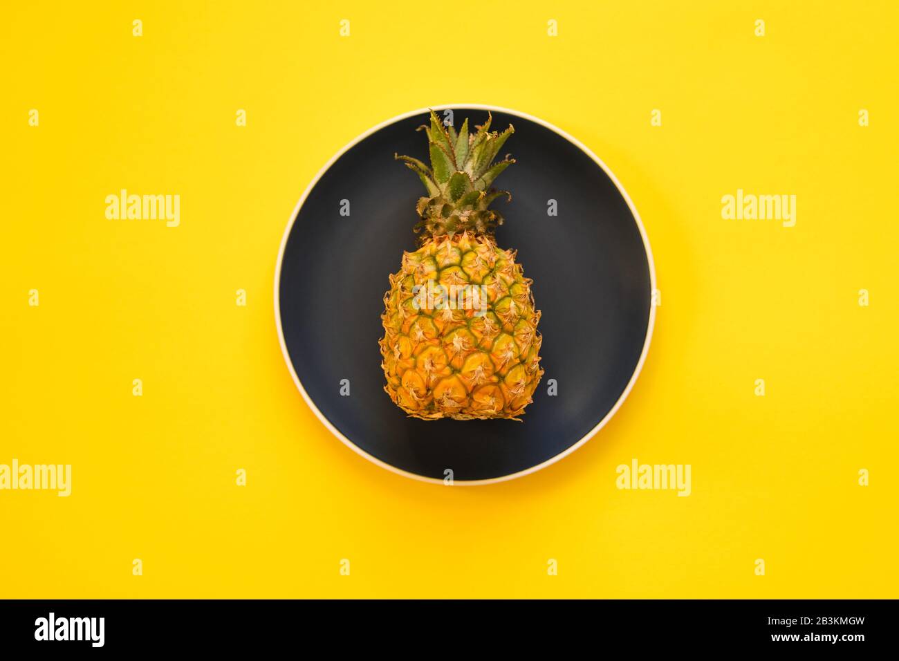 Peu d'ananas sur la plaque sur fond jaune. Pose plate. Concept de nourriture de régime. Fruits Tropicaux. Banque D'Images