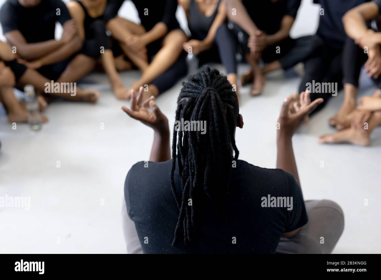 Danseuse masculine parlant à un groupe de danseurs modernes dans un studio Banque D'Images