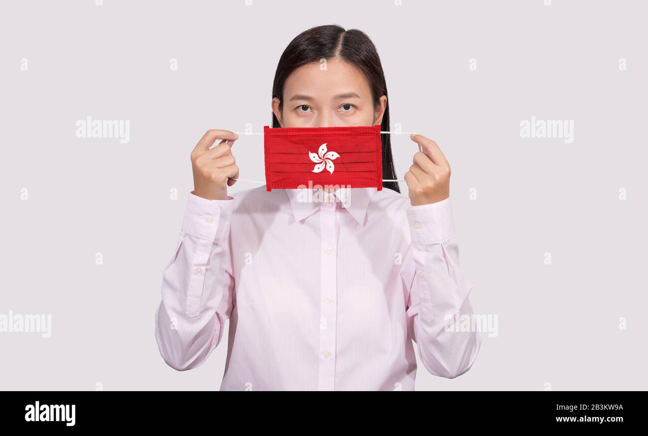 Une femme asiatique portant un masque facial hygiénique peignant le drapeau de Hong Kong pour se protéger de la situation d'éclosion d'infection du Coronavirus 2019 (COVID-19), le virus Banque D'Images