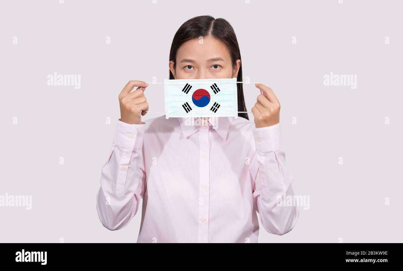 Femme asiatique portant un masque facial hygiénique peignant le drapeau de la Corée du Sud pour se protéger de la situation d'éclosion d'infection du Coronavirus 2019 (COVID-19), le vir Banque D'Images