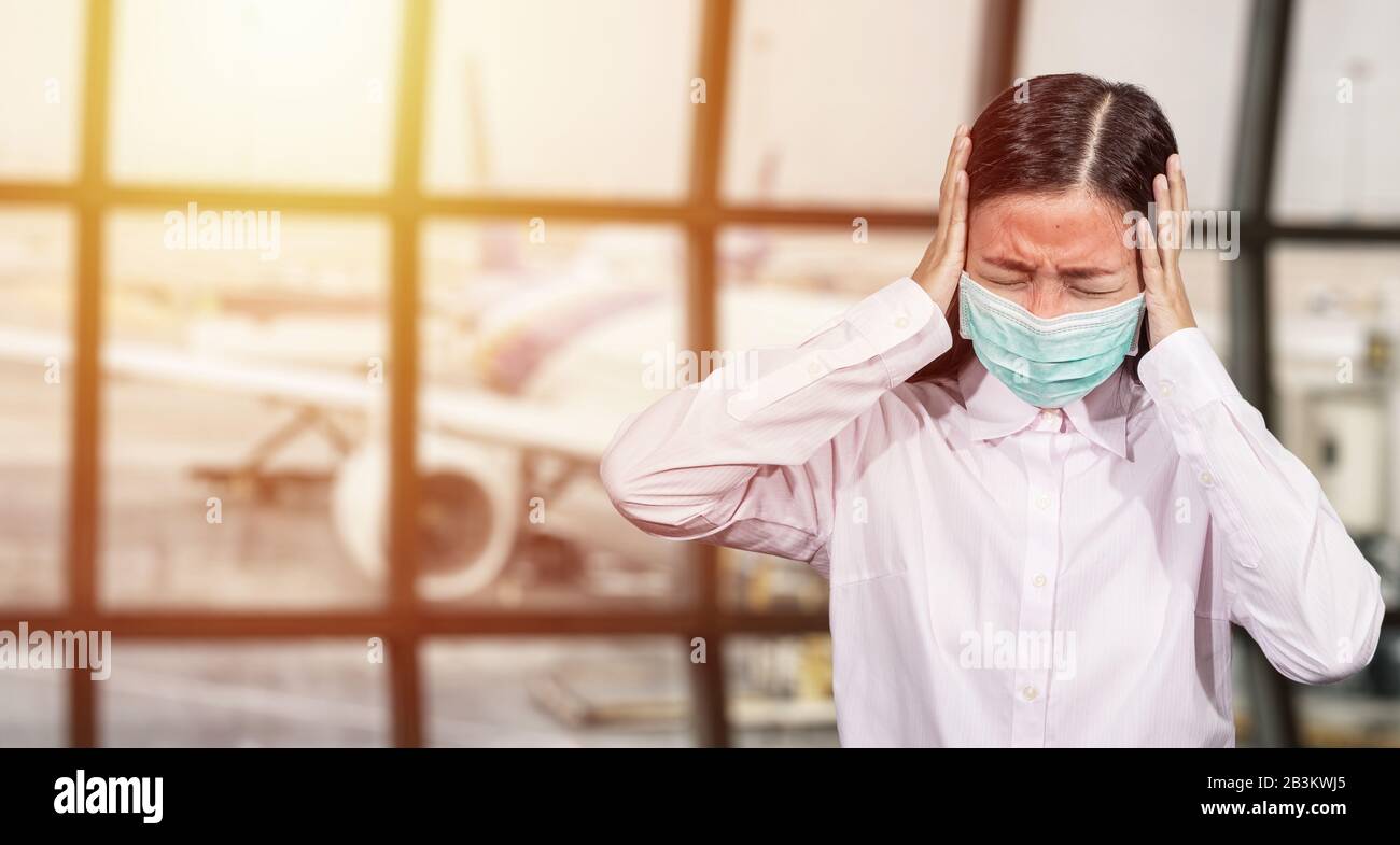Les touristes asiatiques se sentent malades, ont de la fièvre, portant un masque hygiénique pour empêcher pendant le voyage au terminal de l'aéroport de se protéger du nouveau Co Banque D'Images