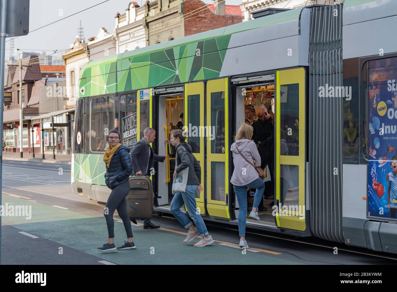 Les gens qui partent, s'en vont (descendre) d'un tramway moderne de Melbourne en direction de Brunswick Street, Fitzroy à Victoria, en Australie le matin. Banque D'Images