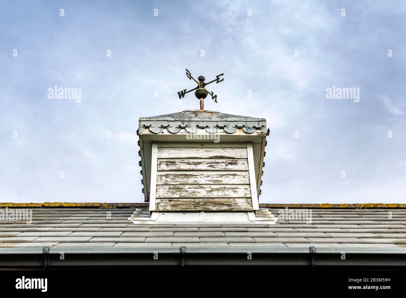 Un weathervane se trouve au-dessus d'une coupole en bois qui est finie avec des éclats de plomb ornementé. Banque D'Images