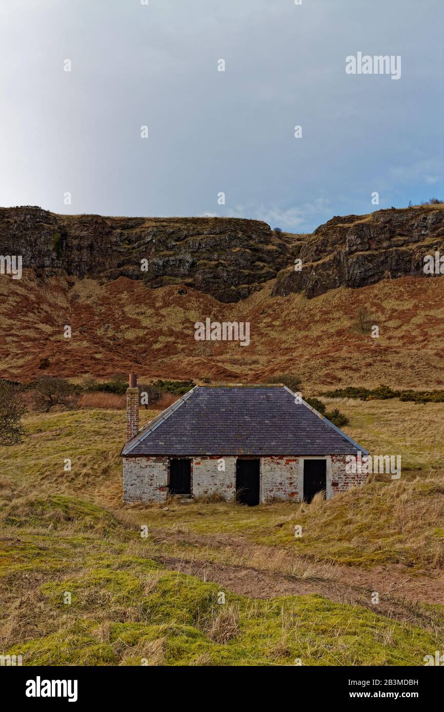 Un cottage abandonné Pour Les Pêcheurs, situé à St Cyrus, est à l'abri des falaises volcaniques. Banque D'Images