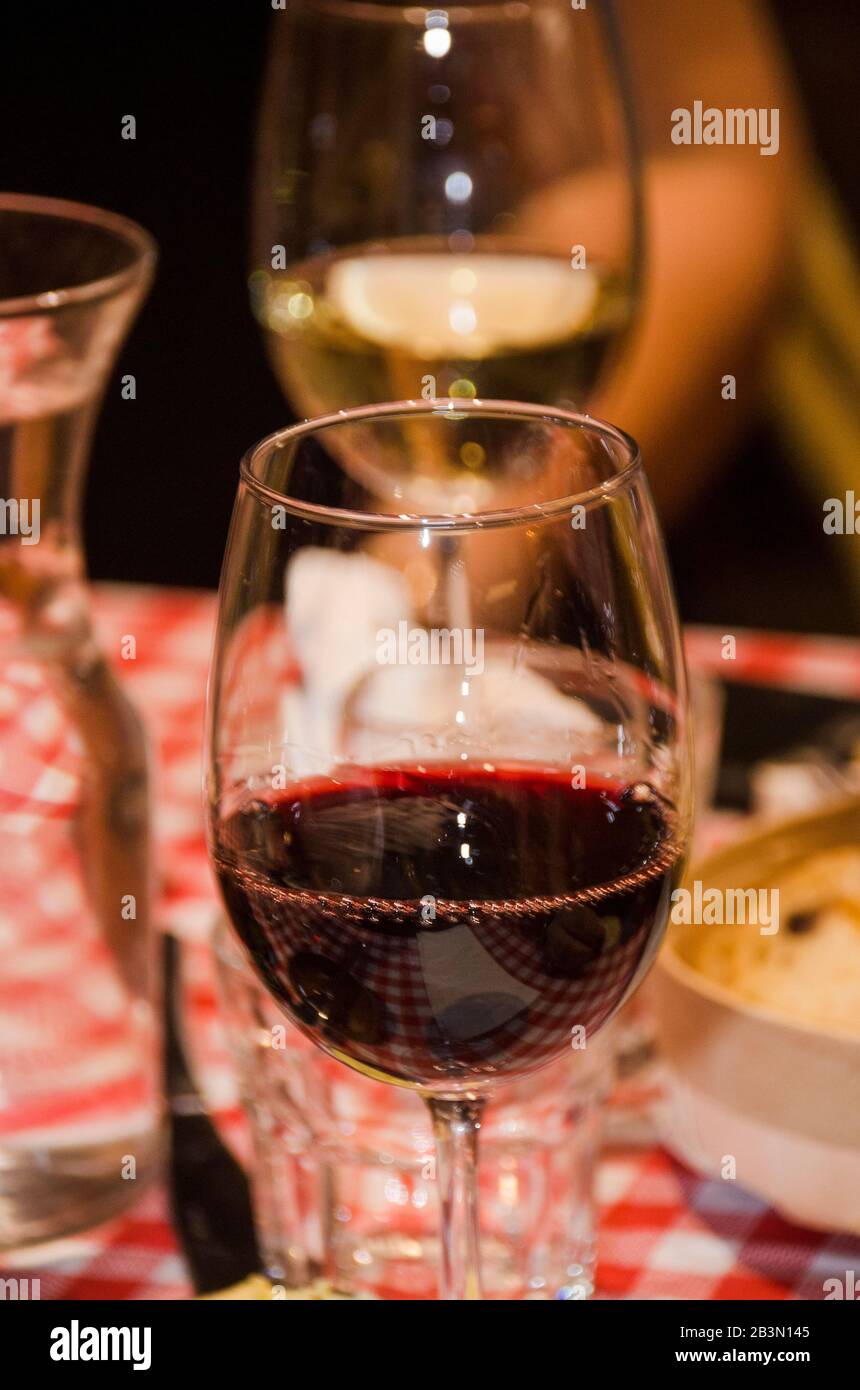 Un verre de vin rouge à une table chargée d'en-cas et d'aliments pour les doigts Banque D'Images