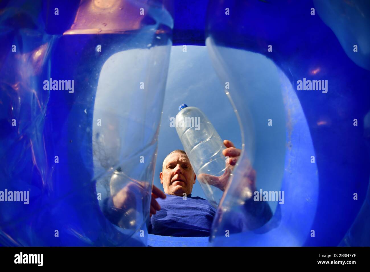 homme mettant des bouteilles en plastique dans la circonscription est du yorkshire recyclage wheie bin ellerton yorkshire royaume-uni Banque D'Images