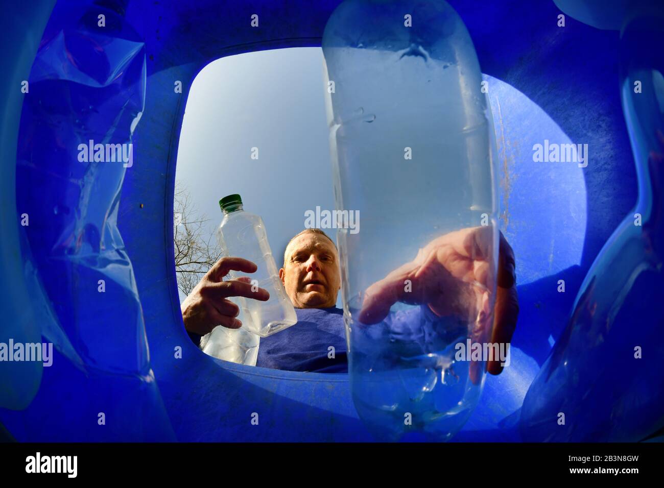 homme mettant des bouteilles en plastique dans la circonscription est du yorkshire recyclage wheie bin ellerton yorkshire royaume-uni Banque D'Images