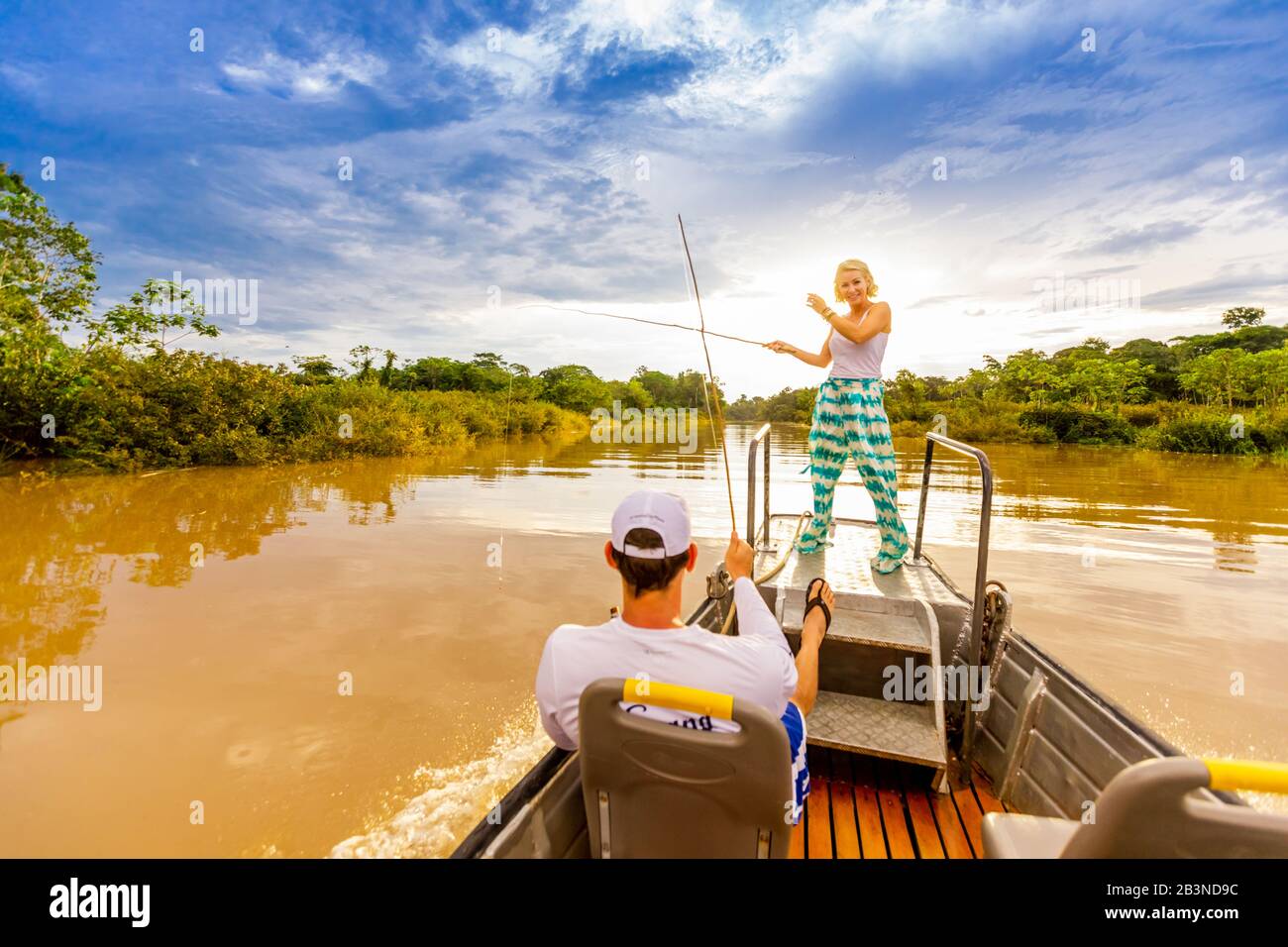 Femme et homme pêchant sur un petit bateau dans la rivière Amazone, au Pérou, en Amérique du Sud Banque D'Images