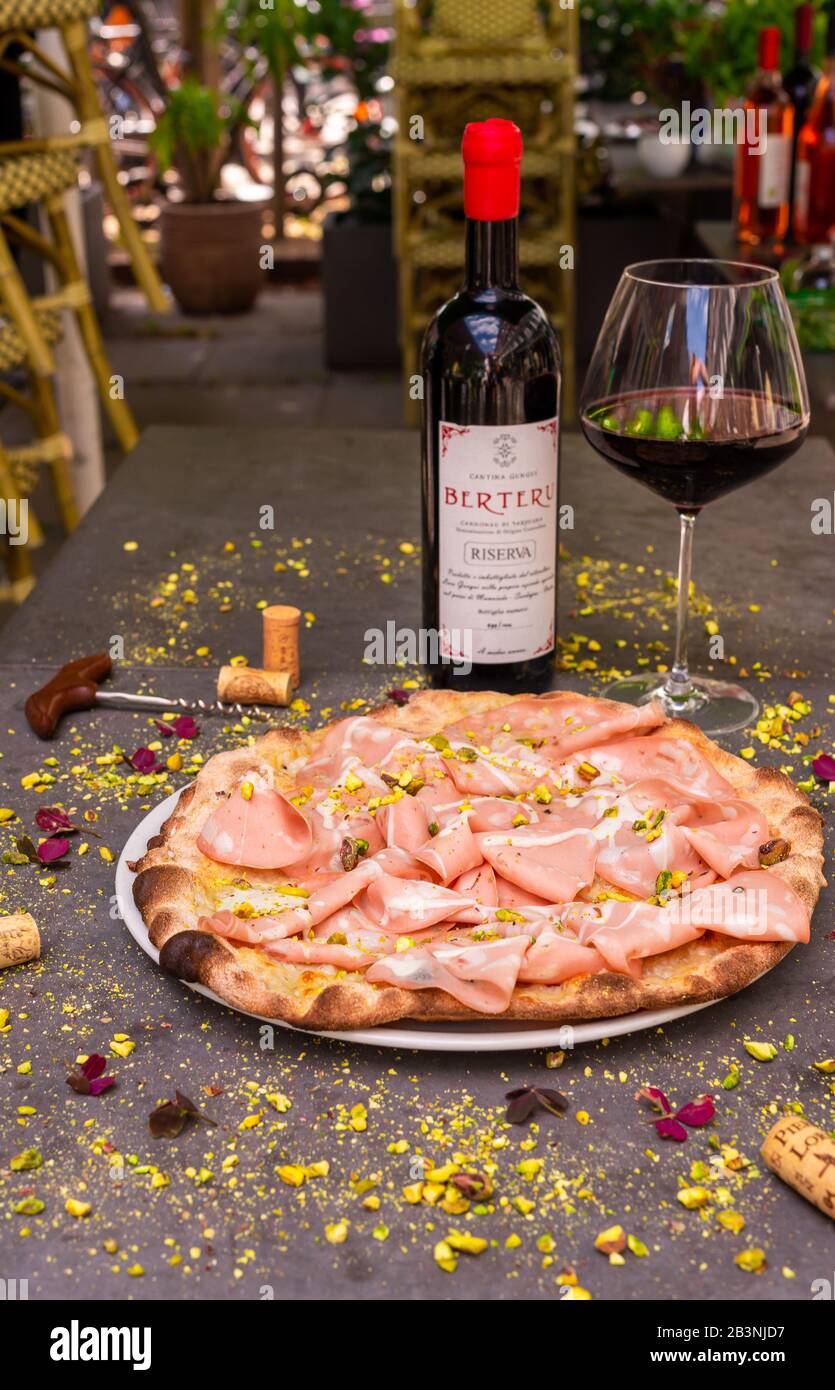 La mortadella rustique a surmonté la pizza avec du vin rouge au restaurant italien Banque D'Images