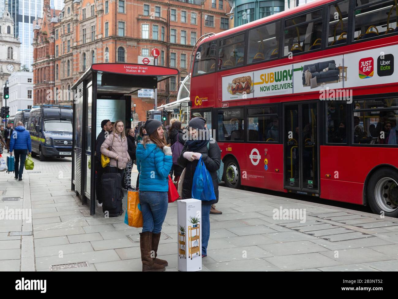 Arrêt de bus de Londres ; arrêt de bus de Liverpool Street, Londres UK - les gens et un bus à l'arrêt de bus sur Liverpool Street, Londres   UK Banque D'Images