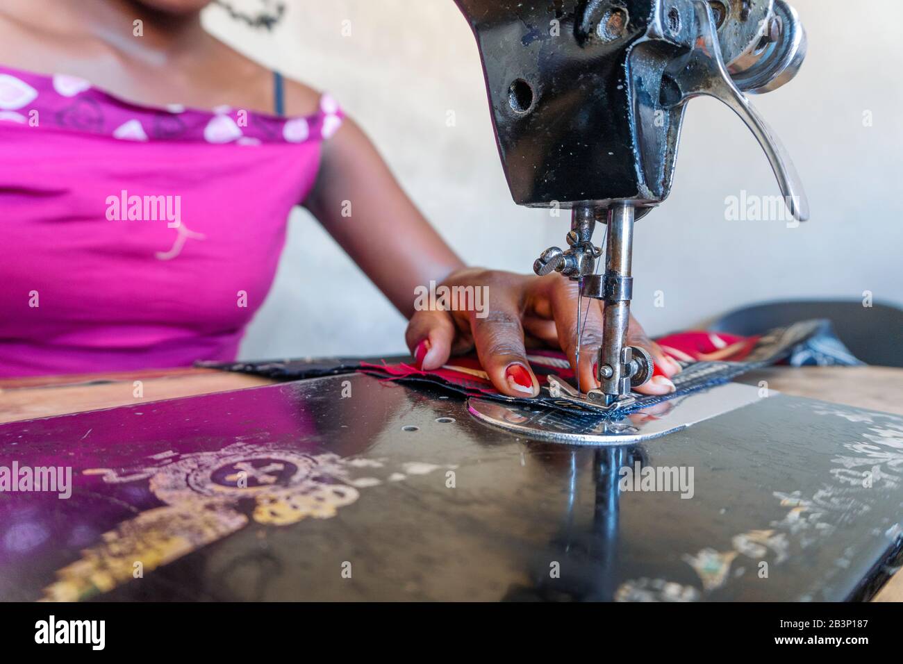 Couturière utilisant sa machine à coudre noire pour faire des robes africaines au Mozambique Banque D'Images