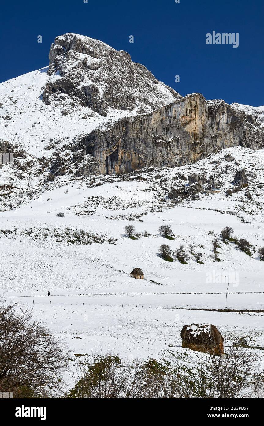 Randonneurs et téitos en PR.AS-15 randonnée et montagnes enneigées en arrière-plan (Valle del Lago, Somiedo Natural Park, Asturies, Espagne) Banque D'Images