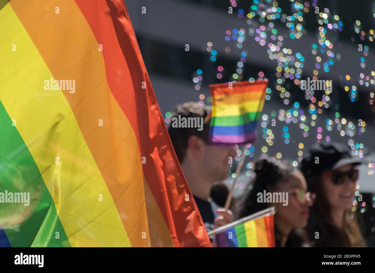 Drapeau de fierté à la parade Toronto Pride avec des gens en arrière-plan et fond de bulle bokeh juin 2019 Banque D'Images