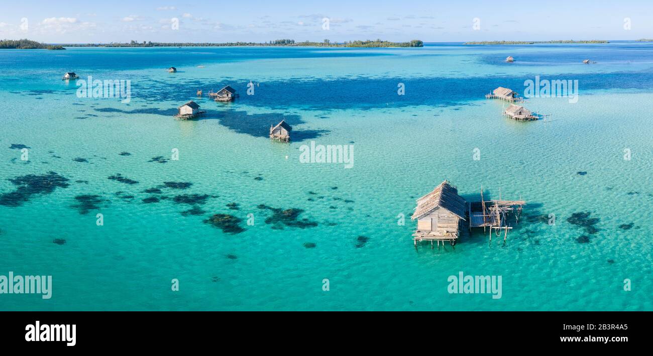Une vue panoramique sur les oiseaux montre un village de pêche indonésien rustique construit sur un récif de corail près d'îles tropicales éloignées dans la mer de Halmahera. Banque D'Images