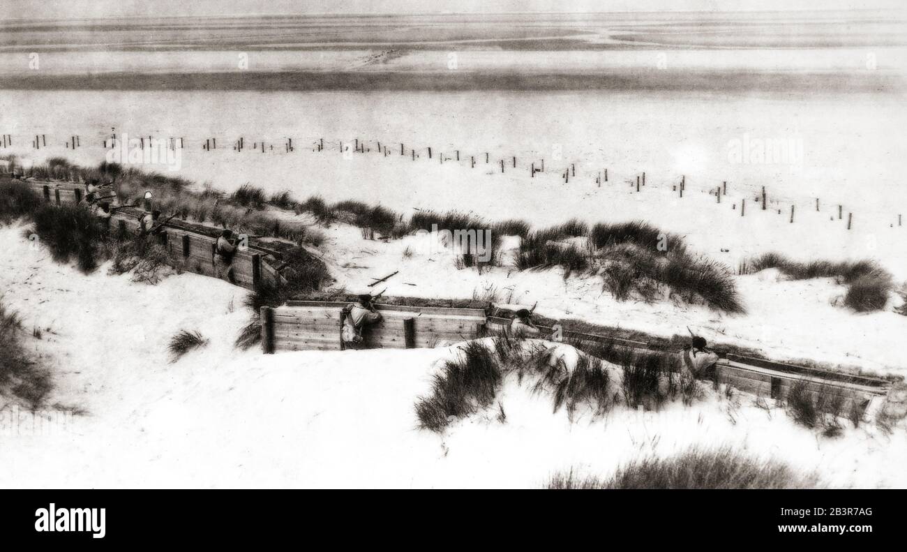 Les soldats mangeant une tranchée dans les dunes de sable longeant la côte de la mer du Nord près de la frontière entre la Belgique et les Pays-Bas en 1915. Banque D'Images