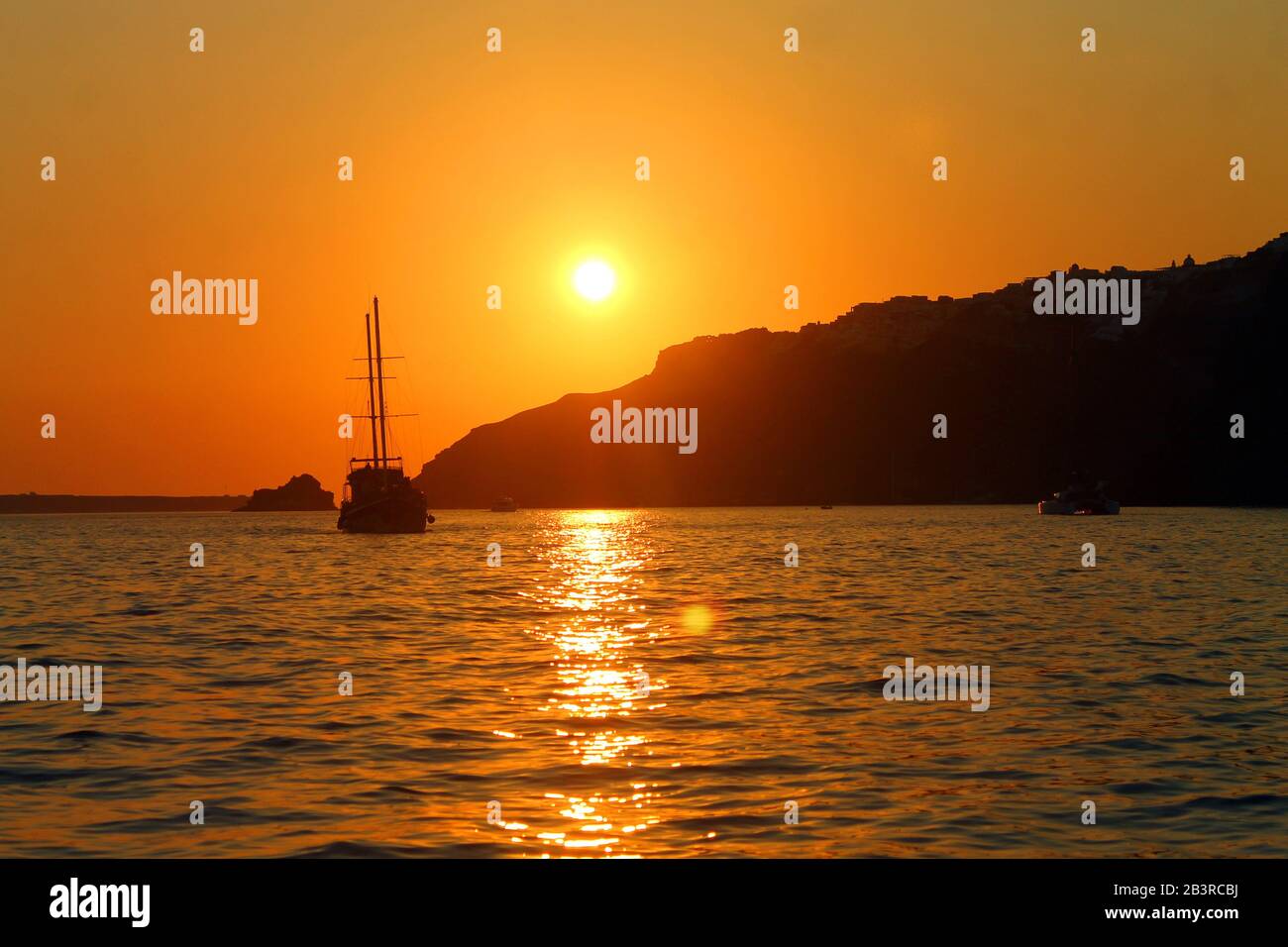 Coucher de soleil orange avec un bateau en Grèce Banque D'Images