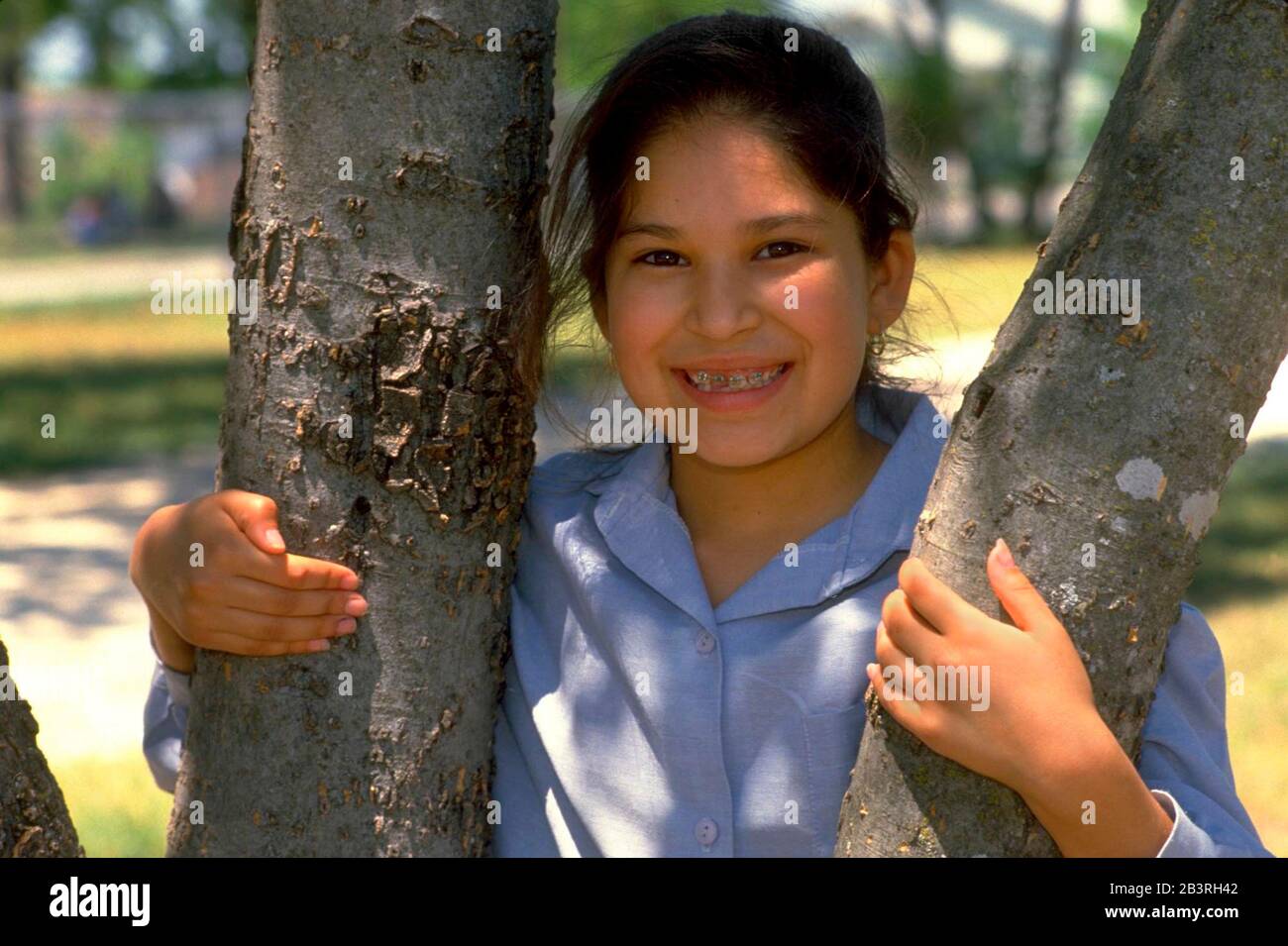 Jeune fille hispanique avec bretelles sourires pour appareil photo.©Bob Daemmrich Banque D'Images