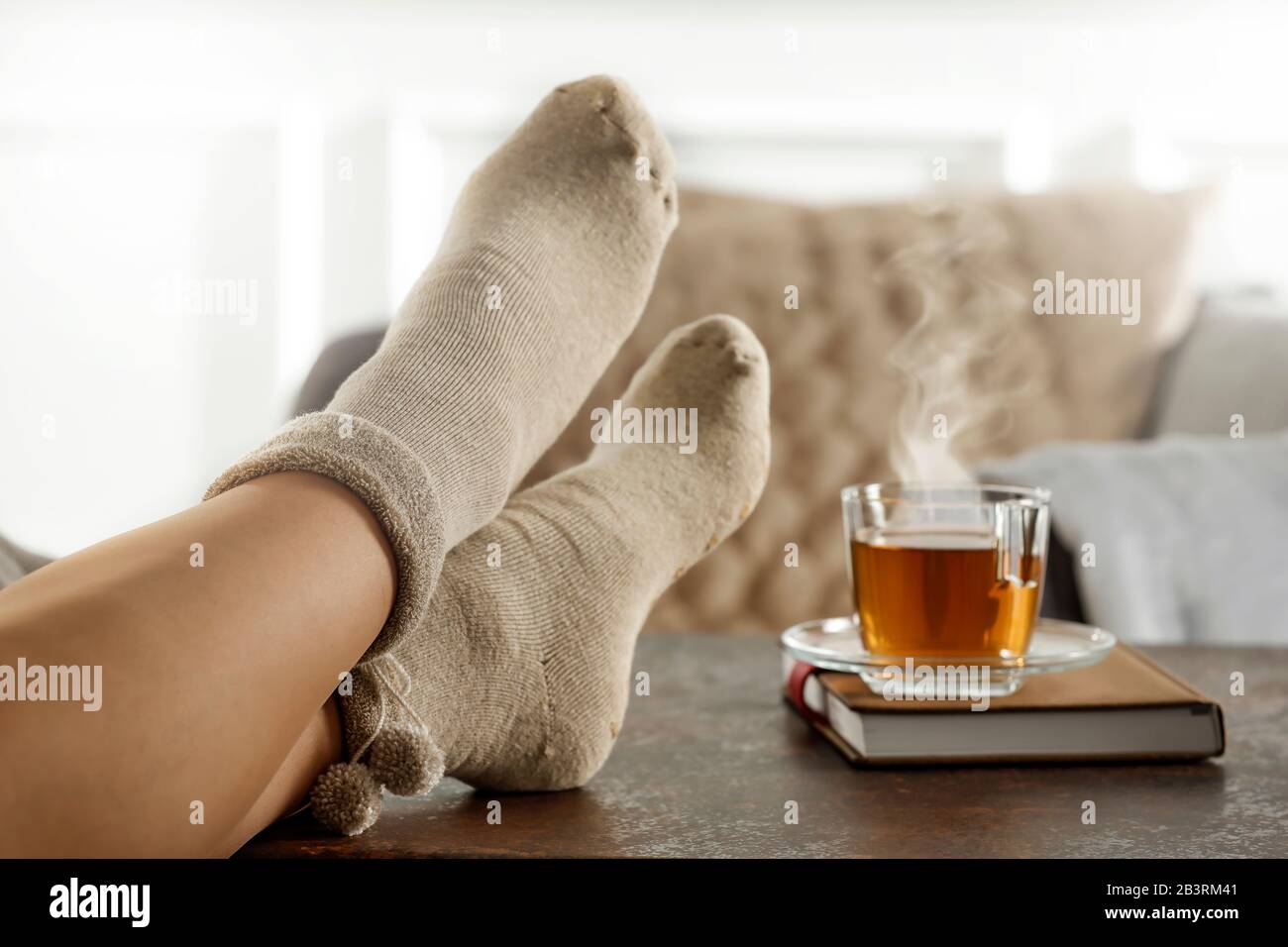 Les jambes de la femme dans des chaussettes sur le fond de la fenêtre de printemps avec de l'espace pour un produit publicitaire. Banque D'Images